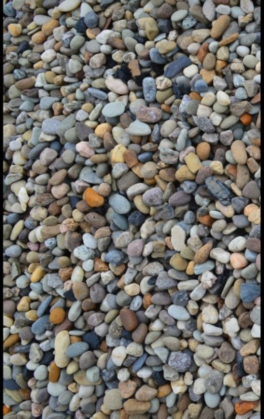 Tightly packed smooth river rock in grey, tan and muted red